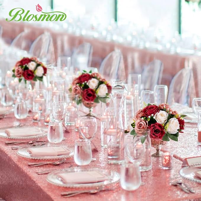 Decorated table with floral centerpieces and clear glasses, featuring the 'Blosmon' brand.